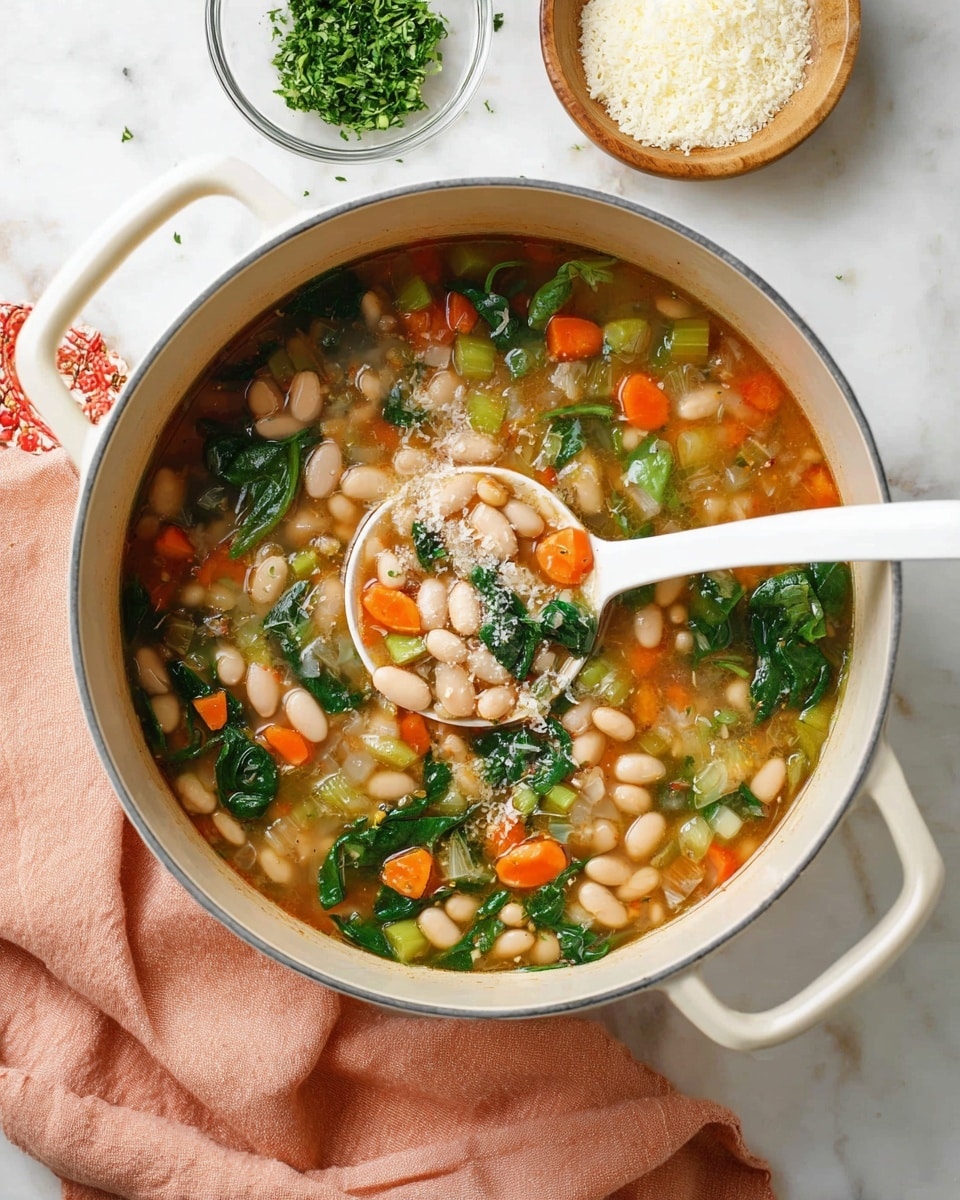 A large white pot is filled with a colorful bean soup showing white beans, bright orange carrot cubes, light green celery slices, and dark green spinach leaves floating in a light brown broth. A white ladle scoops up some of the soup, highlighting the mix of beans and vegetables with a light sprinkling of grated cheese on top. Around the pot, there is a small glass bowl with chopped green herbs and a white bowl with grated cheese, all placed on a white marbled surface with a soft peach-colored cloth nearby. Photo taken with an iphone --ar 4:5 --v 7