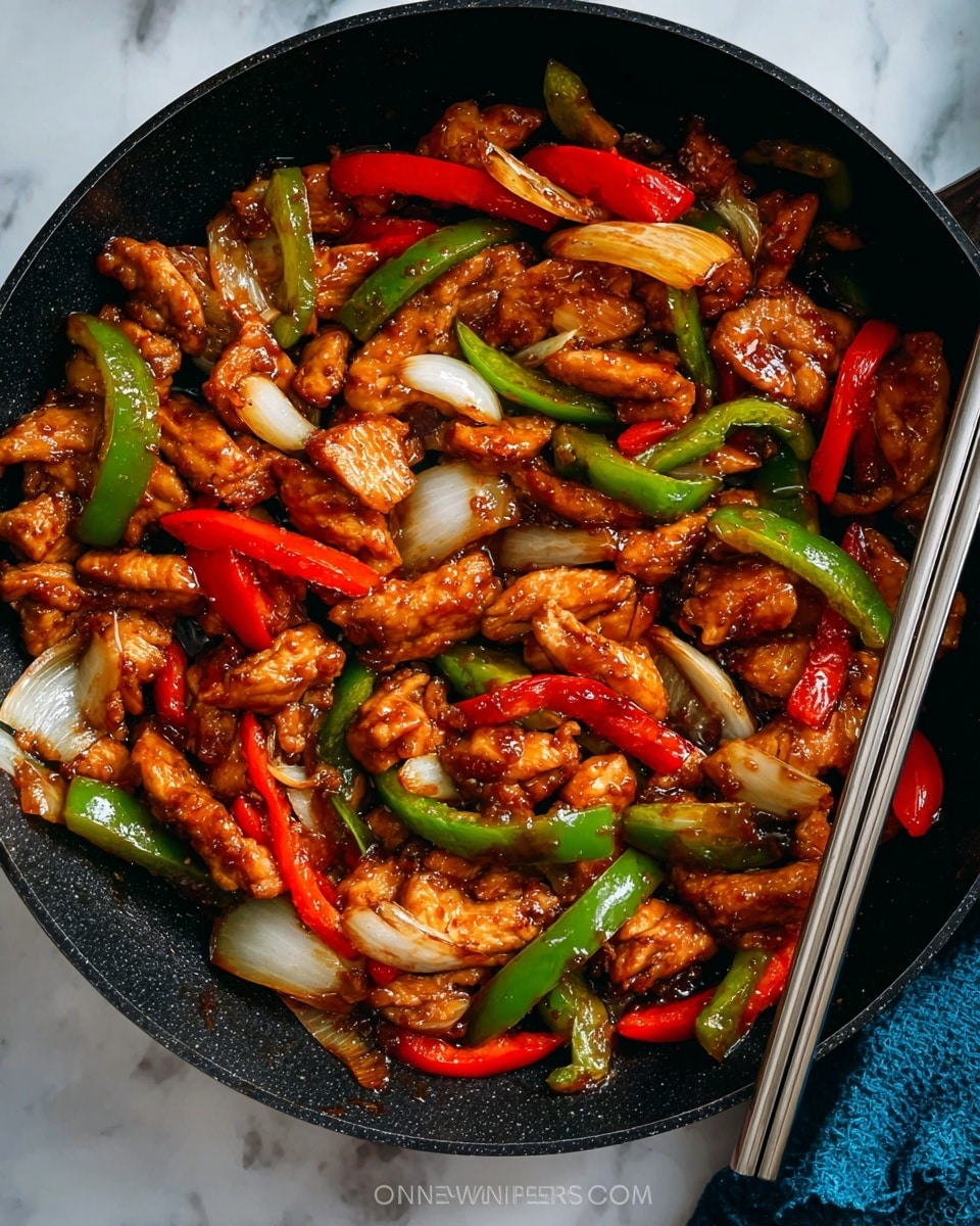 The image shows a close-up of a pan filled with stir-fried chicken and vegetables. The dish has three main layers: the bottom layer is a dark pan, the middle layer has tender pieces of golden-brown chicken coated in a shiny sauce, and the top layer consists of bright red and green bell pepper strips along with translucent white onion slices. The ingredients are mixed evenly, showing glossy textures from the sauce. A pair of metal chopsticks is partly visible on the right side, with a portion of a blue cloth underneath. The whole scene is set against a white marbled texture. photo taken with an iphone --ar 4:5 --v 7