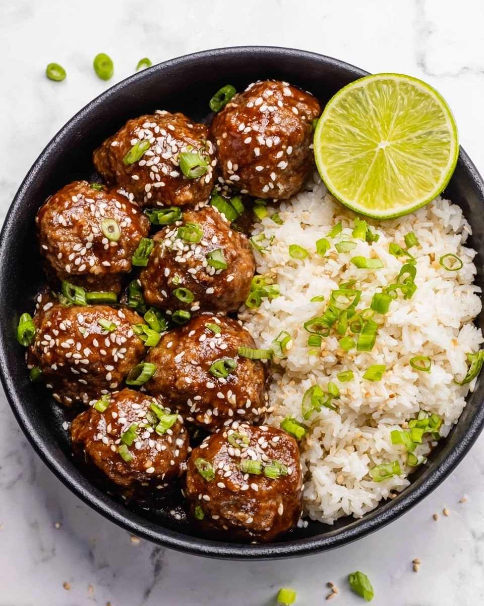 A black bowl holds a serving of meatballs and rice arranged side by side on a white marbled surface. The left side has nine glossy, brown meatballs coated in a shiny sauce, each topped with white sesame seeds and small pieces of green onions. On the right side, there is a heap of white rice mixed with scattered chopped green onions, giving it a fresh touch. A bright green lime wedge rests between the meatballs and rice at the top edge of the bowl. There are some sesame seeds and green onion bits scattered on the white marbled surface around the bowl. photo taken with an iphone --ar 4:5 --v 7