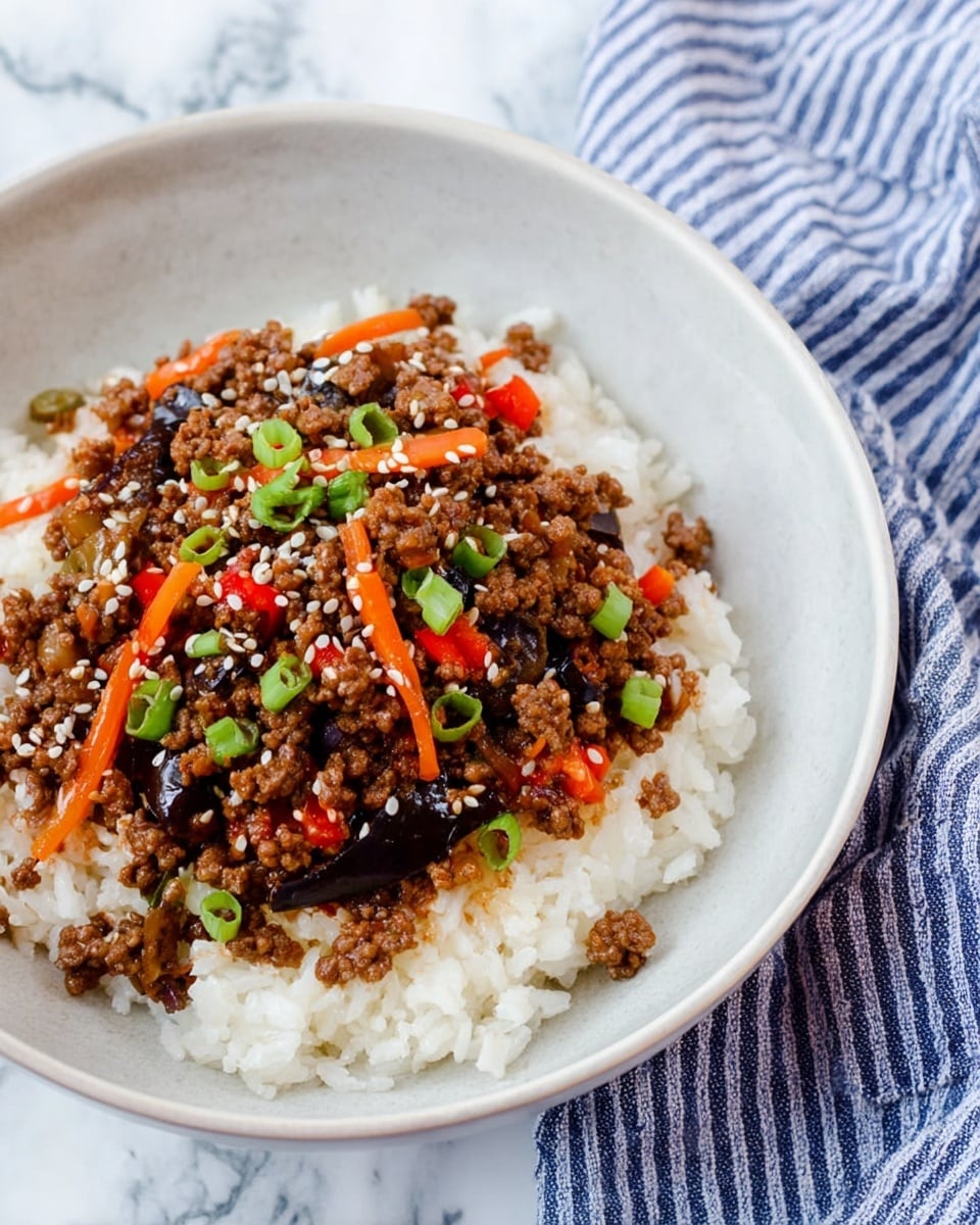 A shallow white bowl filled with a base layer of white cooked rice, topped with a layer of ground beef mixed with small bright red chopped bell peppers, thin orange carrot strips, and dark glossy pieces of mushrooms or eggplant. The beef mixture is sprinkled with white sesame seeds and small green sliced scallions, adding color contrast. The bowl is placed on a white marbled surface next to a blue and white striped cloth napkin. Photo taken with an iphone --ar 4:5 --v 7